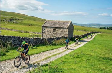 Line of cyclists on rural trail