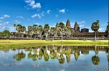 Temple complex with green field and water in front