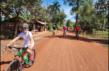 Cyclists riding on red dirt road