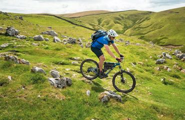 Cyclist riding downhill on grassy slope