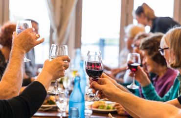 Group at table clinking wine glasses