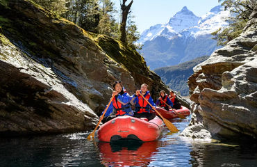 People on inflatable kayaks through rocks