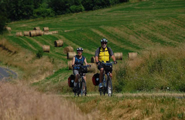 Cycling along a road with fields on side