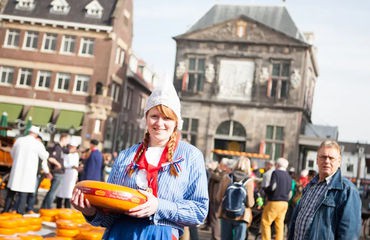 Girl holding cheese in city centre