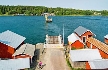 Red buildings at harbour with small ferry incoming