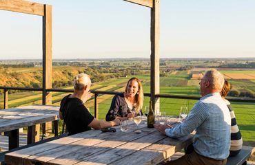 Group sitting at picnic bench overlooking fields