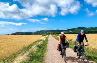 Couple of cyclists on path through fields