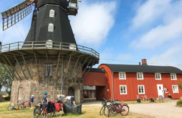 Windmill and iconic red building with cyclists parked out front