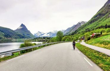 Cyclist on rural road with mountains ahead