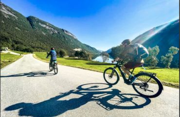 Cyclists on road with mountain to the side