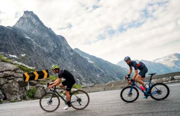 Two road cyclists on descent in mountains