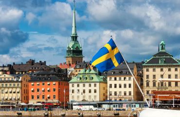 Colourful buildings in city by the way with Swedish flag flying