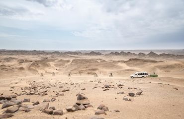 Cyclists riding off in the distance to desert mountains