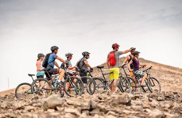 Group of cyclists with one pointing into the distance