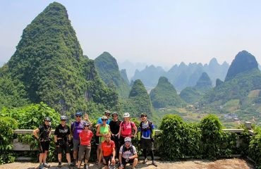 Cyclists in front of a forested mountain
