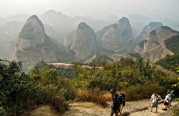 Hikers along a trail with mountains in background