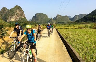 Cyclists riding with limestone karsts in background