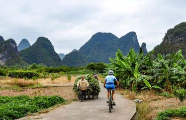 Cyclist on path riding towards karst scenery