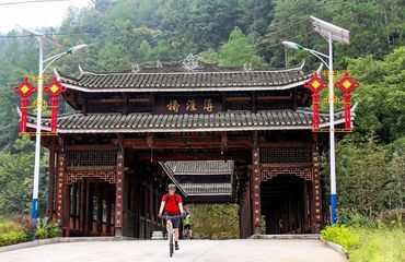 Cyclist coming through a traditional Chinese gate