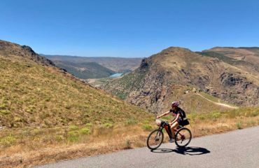Cyclist on road with mountainous backdrop