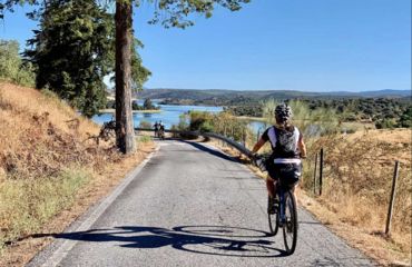 Cyclist on road heading towards the sea