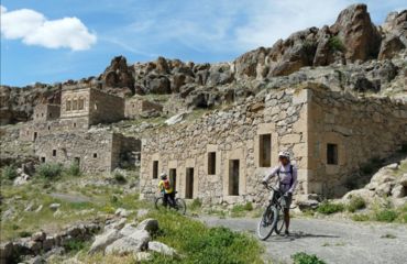 Cyclist outside of stone ruins