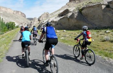 Cyclists on a road towards mountains