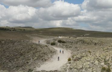 Cyclists on dirt road in sandy region