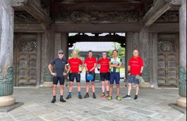 Group of cyclists off the bike standing for a photo in historic building