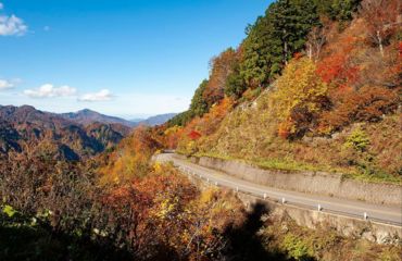 Road on edge of mountain overlooking forests and mountains