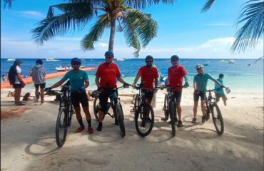 Cyclists posing with bikes by beach