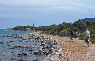 Cyclists riding by the water