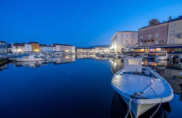 Harbour at night with small boats and buildings surrounding