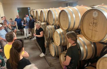 People gathered around wine barrels for talk
