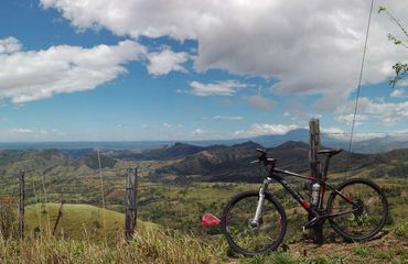Bike leaning against a fence with far reaching mountain views