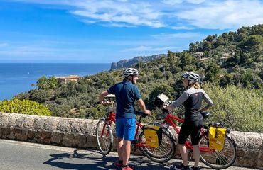 Couple with bikes at viewpoint by the sea