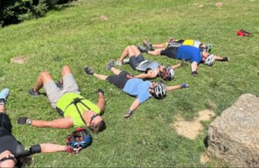 Cyclists off the bike, relaxing on grass
