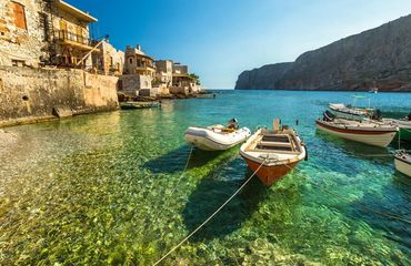 Clear blue water with fishing boats and historic village
