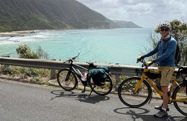 Cyclist on a coastal road with another bike