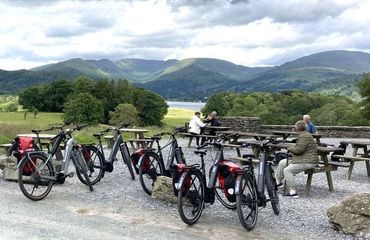 Bikes by picnic benches and people overlooking hills