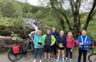 Group with bikes infront of water and greenery