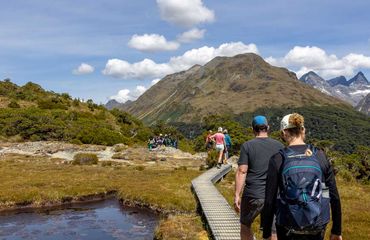 Group hiking on path to mountains