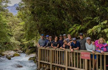 Group of people behind railing overlooking water