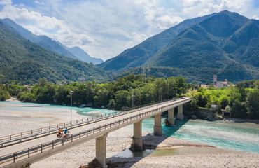 Long bridge across river to green mountains
