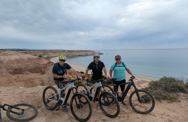 Group of cyclists on a cliff overlooking the ocean