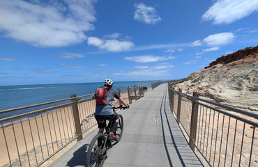Cyclist pedaling along the coast