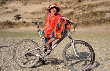 Peruvian on a mountain bike smiling