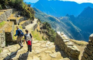 Hikers walking around ancient ruin in mountains