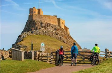 Three cyclists looking at castle on hill