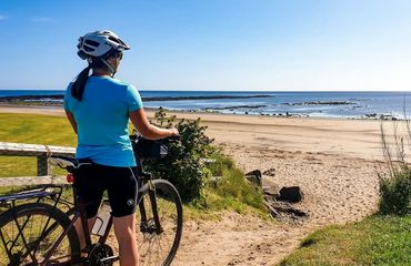 Cyclist looking at sandy beach